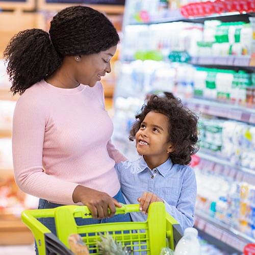 Person and child shopping for groceries.